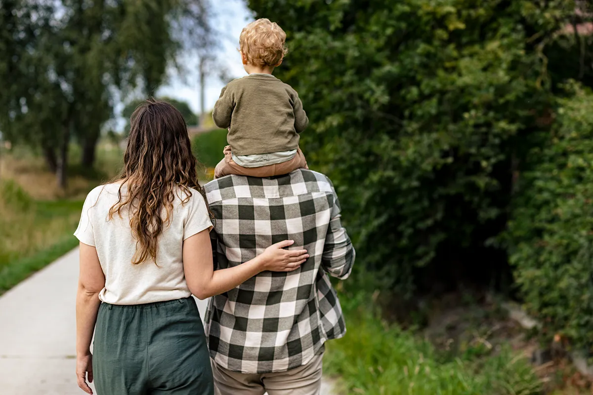 Elien staat links en legt haar hand op de rug van Ruben. Eliah zit in de nek van Ruben en ze kijken weg naar de natuur. Je ziet hoe ze elkaar dragen.